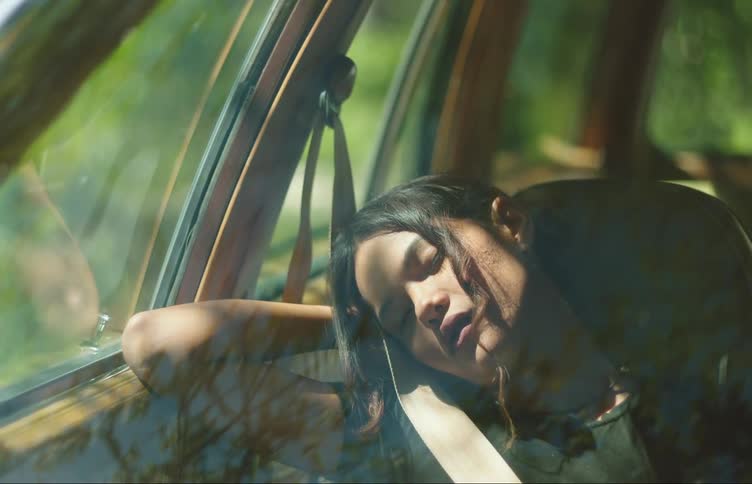 Teenage girl sleeping on the passenger seat of a car