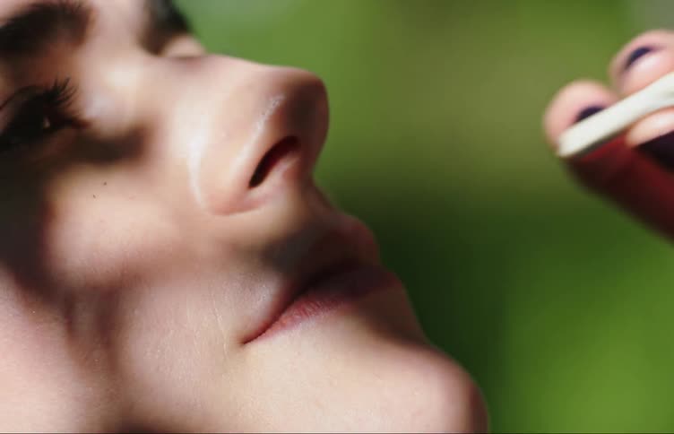 Woman blows smoke into the air while smoking outdoors