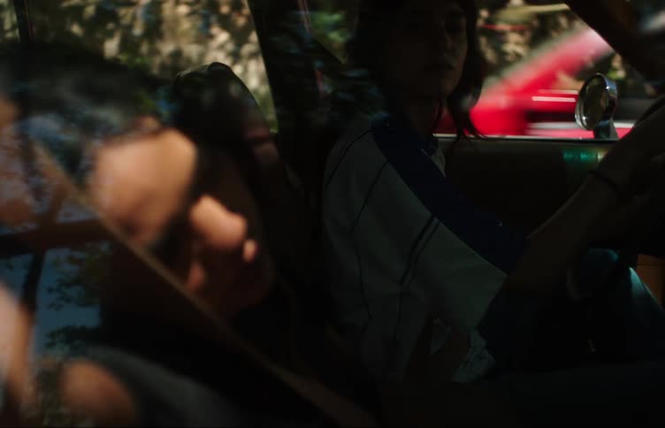 Woman driving a car and next to her a young girl sleeping