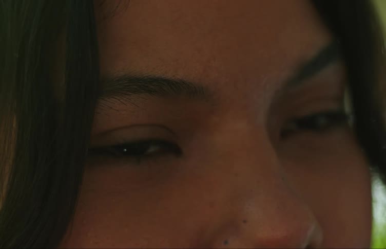 Closeup on the face of a young woman with black eyes and hair