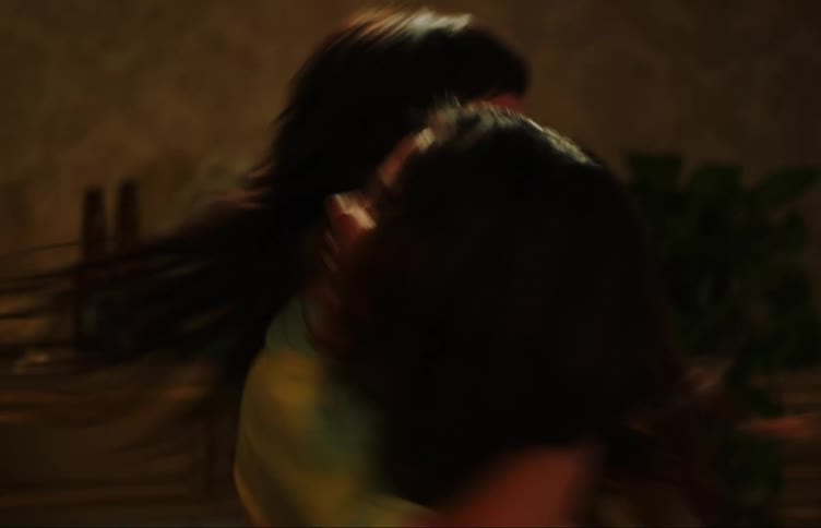 Two female teenagers smile while dancing together at night