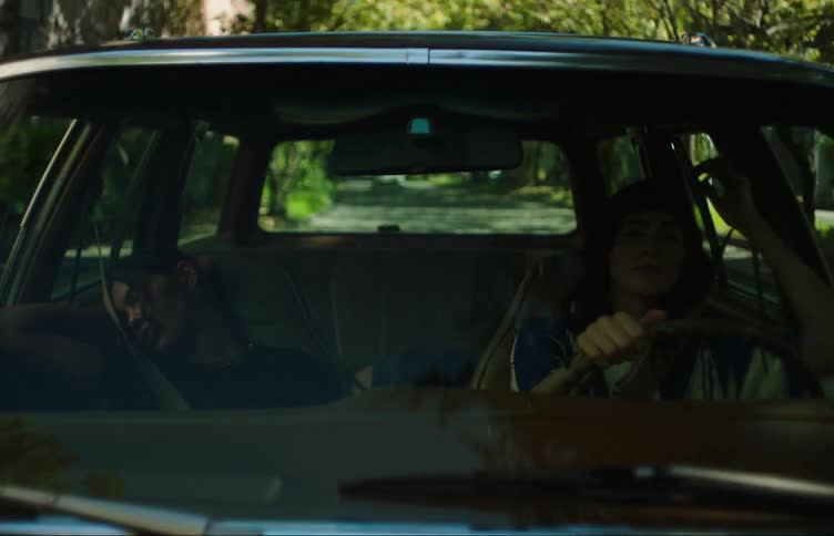 Two woman in a car one is driving the other is asleep