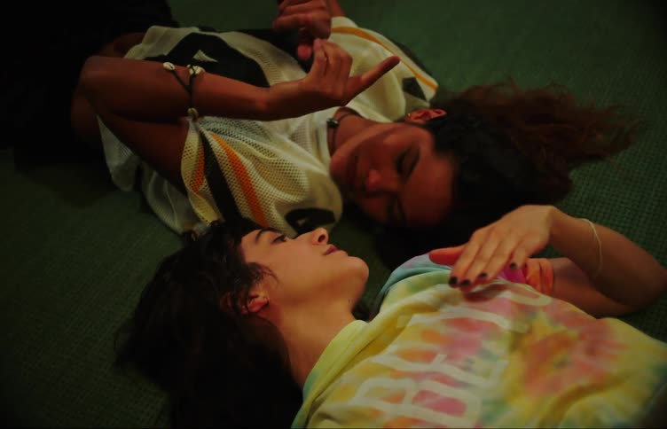 Two girls laughing and singing on the living room floor