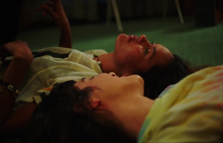 Two friends lay on the ground together laughing