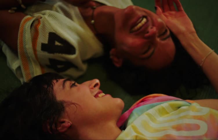 Two teenage girls talking and laughing on the floor