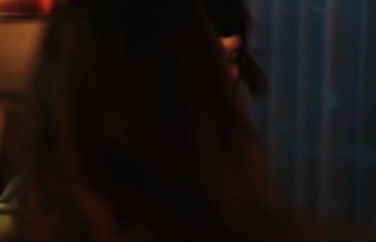 Two teenage girls dancing in a dimly lit room with colorful lights