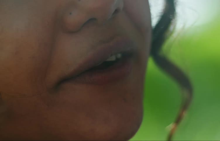 The mouth of a young woman smiling and smoking