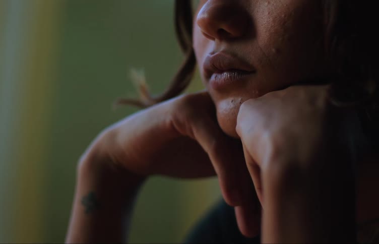 Portrait of a young woman with her hands on her chin with bored facial expression