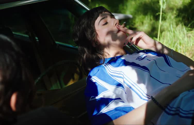 Teenage girls smoking on the hood of a car