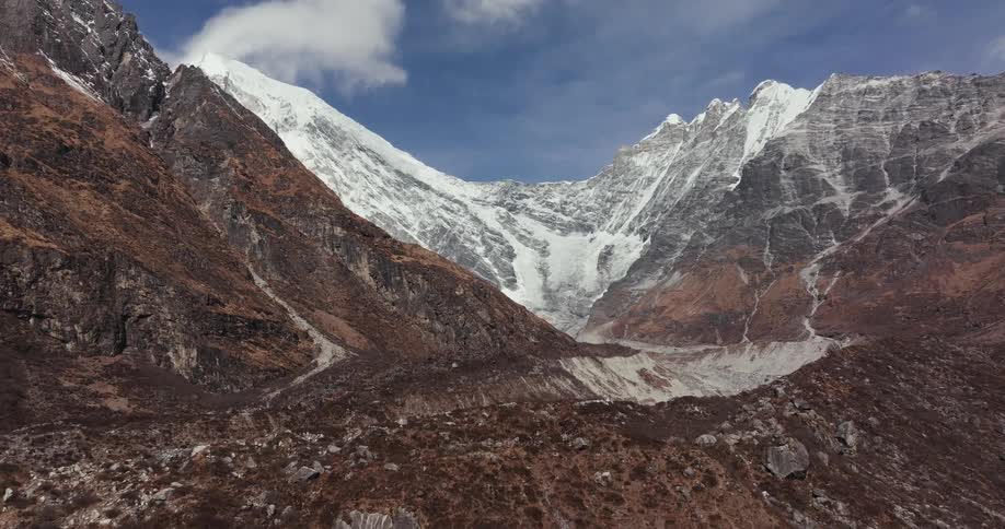 Ice partially fills valley surrounded by mountains under a cloudy sky