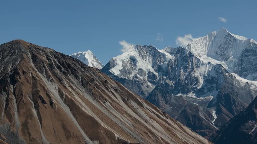 Aerial panorama of a rocky mountain with degradation and in the background other mountains with snow