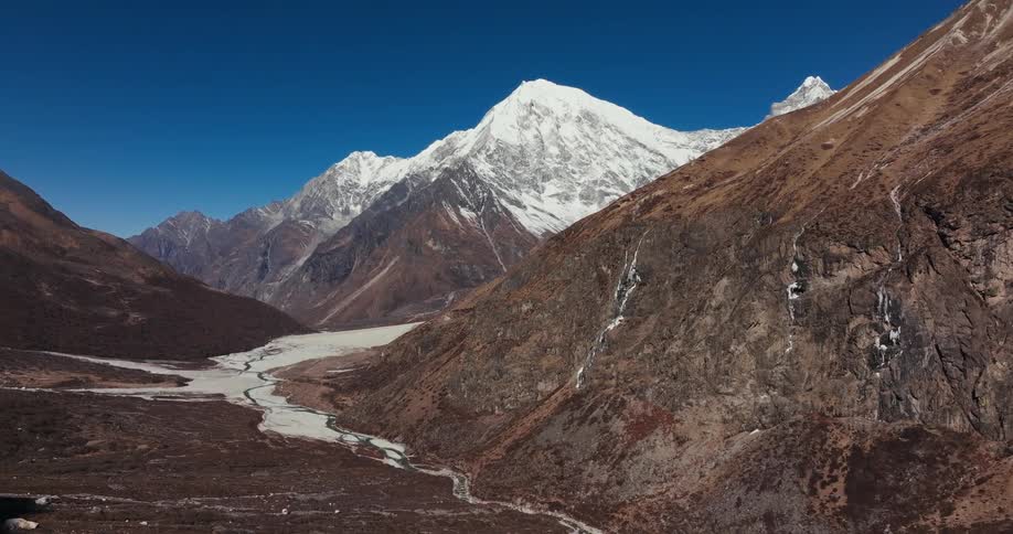Aerial scenery of geological mountain ranges in winter on a cloudless blue sky day