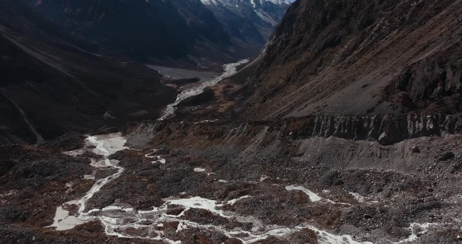 Rocky mountains with natural degradation and cliffs with snow on a cloudless blue sky day