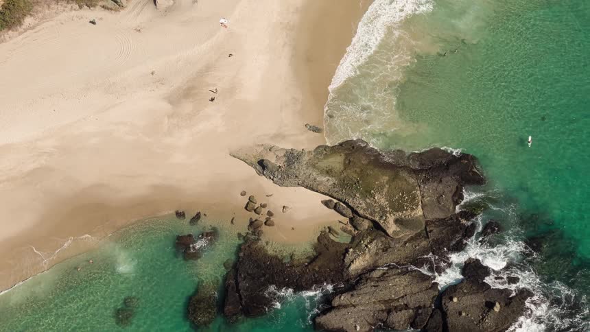 Aerial view of waves gently crashing on a beach