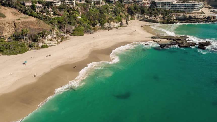 Aerial scenery of a turquoise beach on the coast with urban and hotel areas