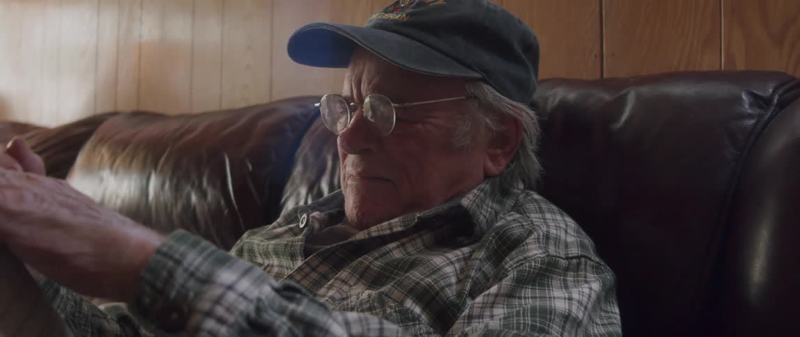 Close up of a sad elderly man tearing a magazine while crying