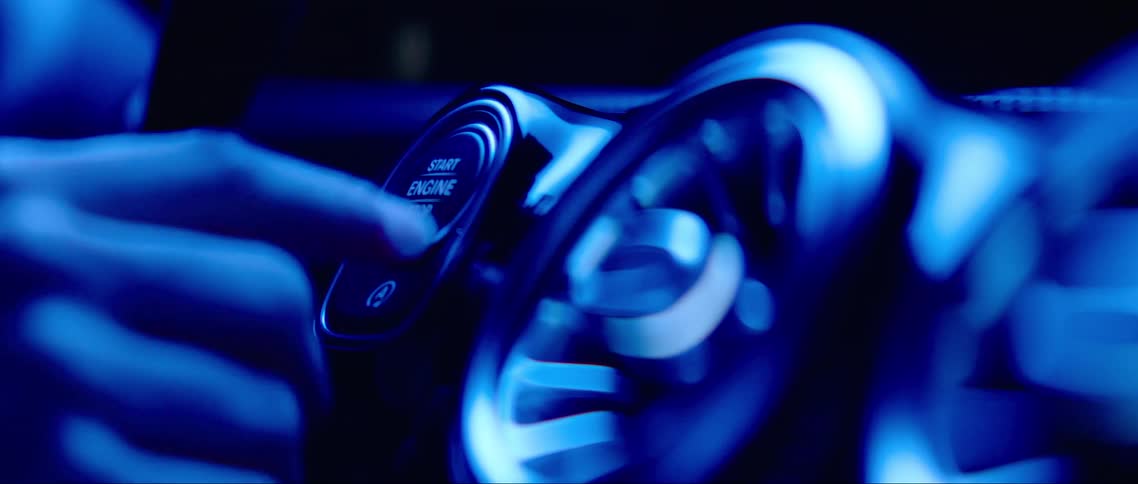 A man starts his car by pushing a button