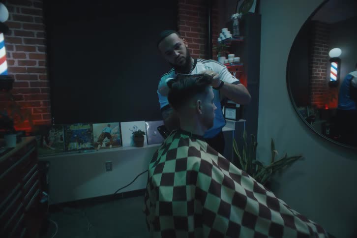A hairdresser combing the hair of a client in the barber shop
