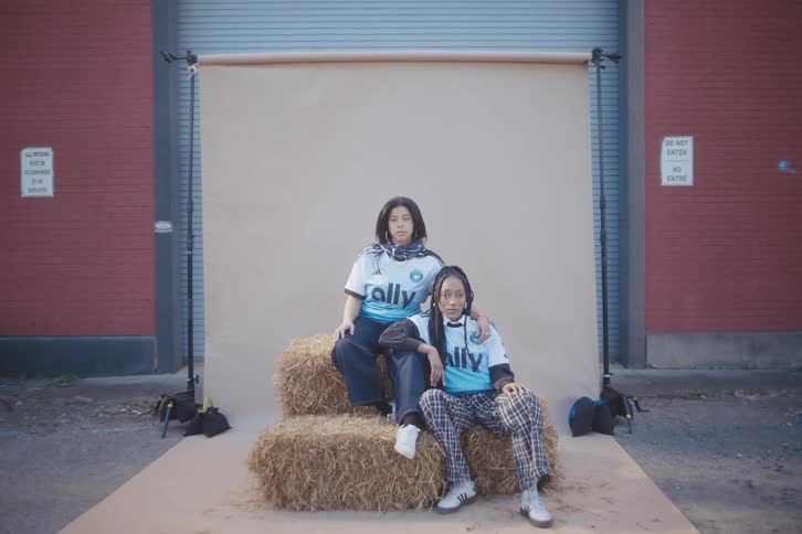 Two young models sitting in a haystack posing