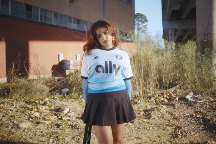 A woman is posing under an overpass