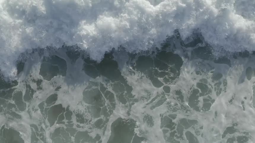 Close up birds eye view of waves crashing in the ocean