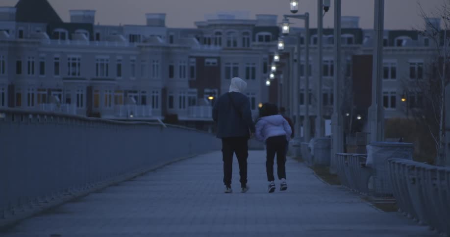 A couple walking on the city at dusk