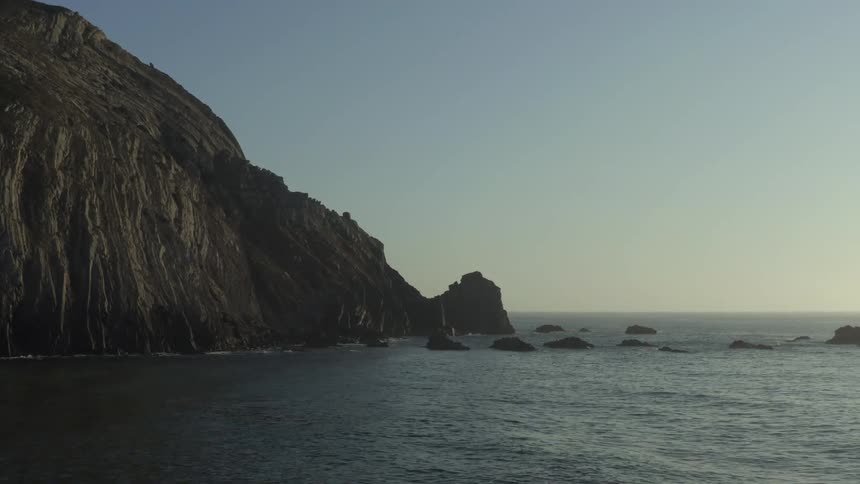 Waves crash against the mountains on the shore