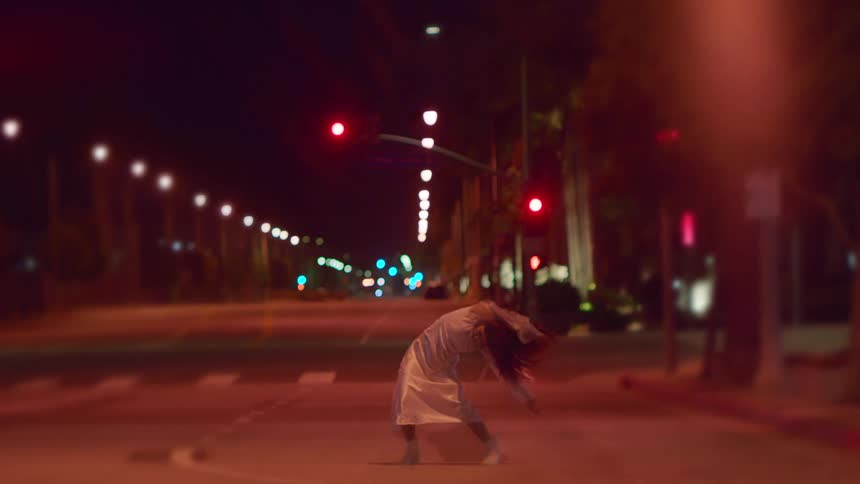 A woman dances in the middle of an empty city street