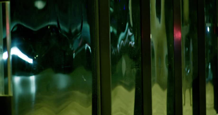 Headlights reflecting on a distorted metallic surface