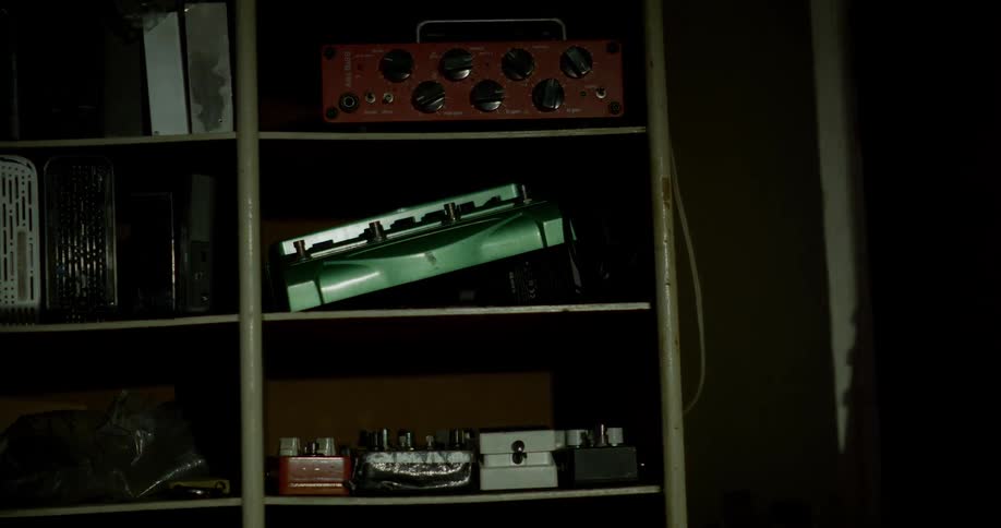 Light passes across vintage instruments stored on a shelf
