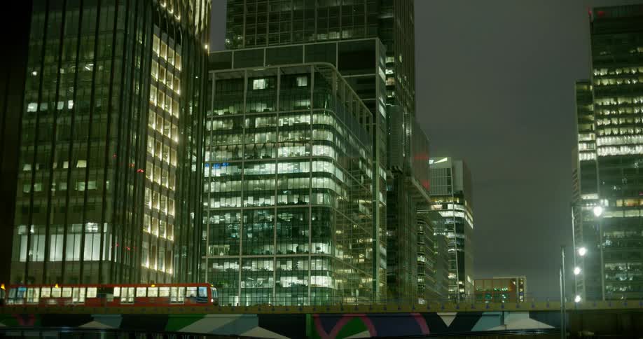 A train moves through a city at night