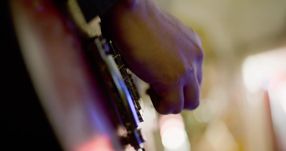 Closeup of a mans hand playing the guitar