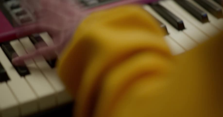 Hands vigorously playing on a synth keyboard