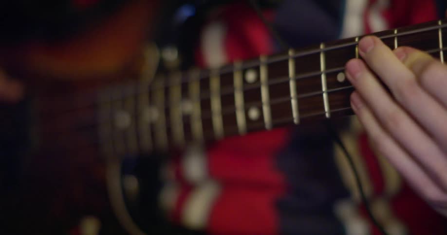 Hands of a man playing bass guitar