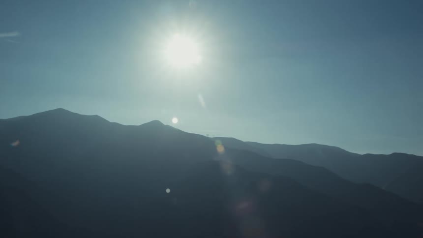 The sun shining over a mountain range