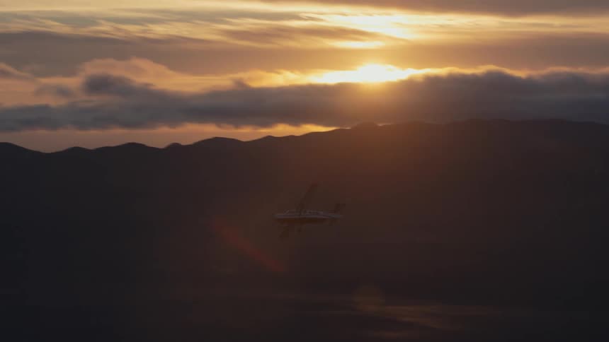 Small singleengine plane flying over the sky on a sunrise morning