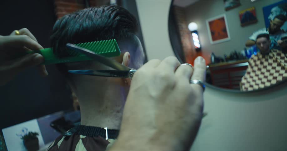 Hands of a barber giving a man a haircut