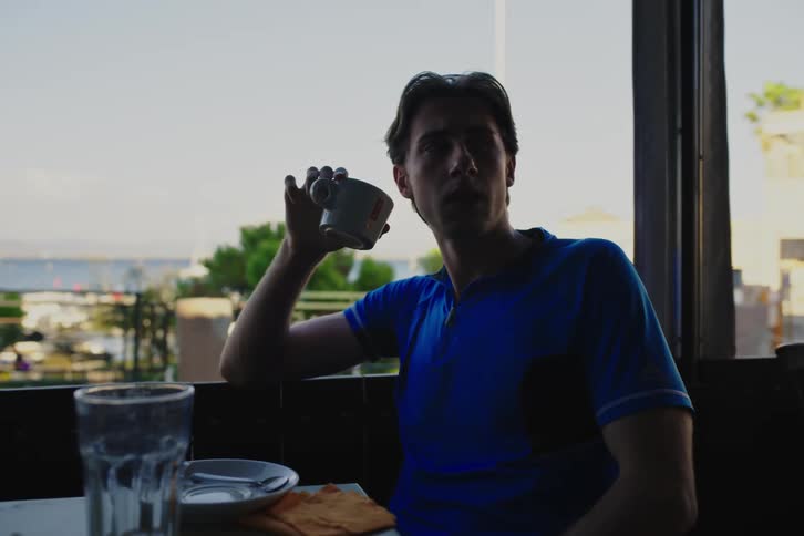 Three young men at a cafe drinking and talking