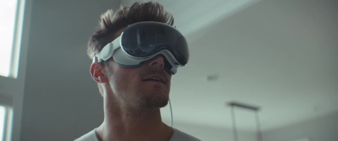 Man wearing vr headset turns his head to view virtual environment while standing in home