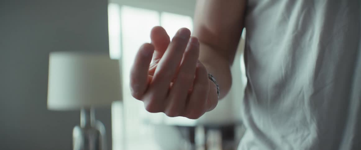 Man standing at home gestures with one hand as part of a interface