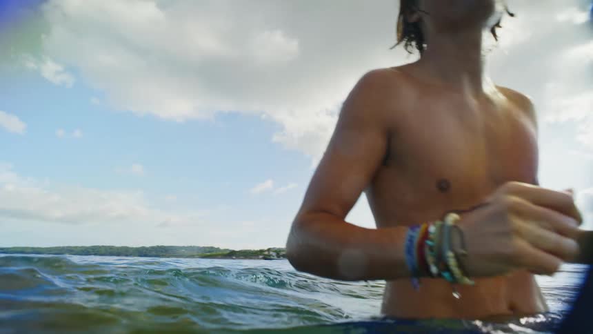 A guy throws a ball around in the ocean