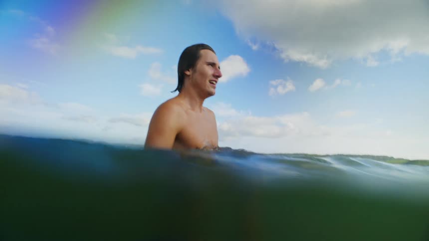 A man throws a ball in the ocean