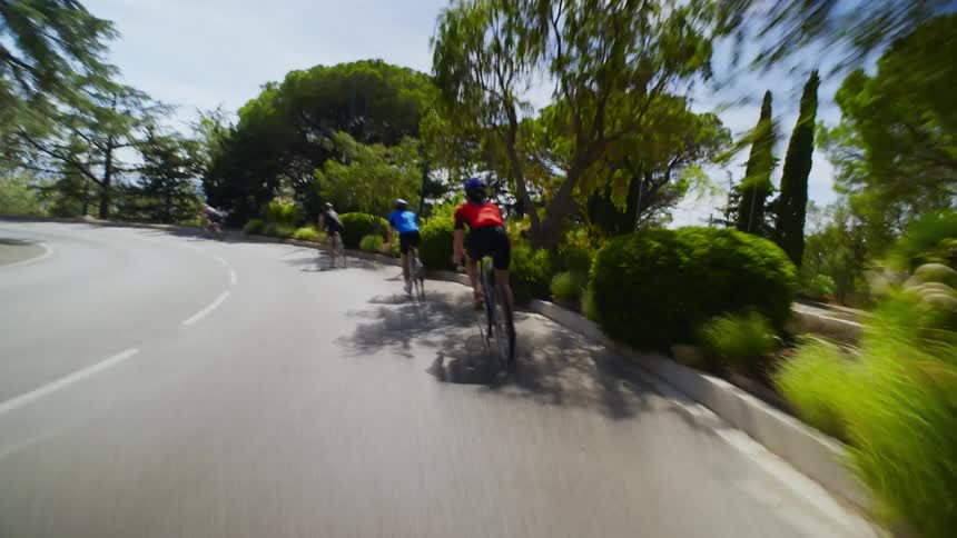 Group of cyclists one behind the other cycling on a twoway street during the day