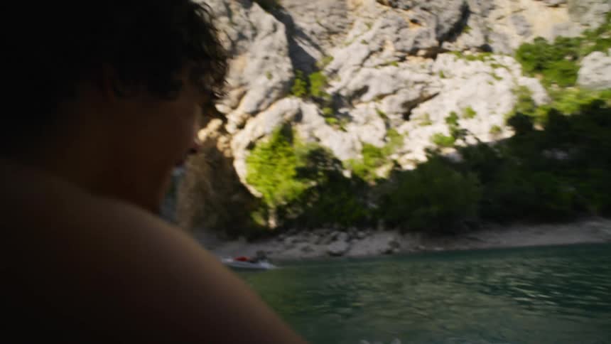 Two friends talking on a yacht with one of them judging each other in the sea with their backs turned