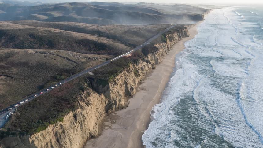 Traffic flows past the shore