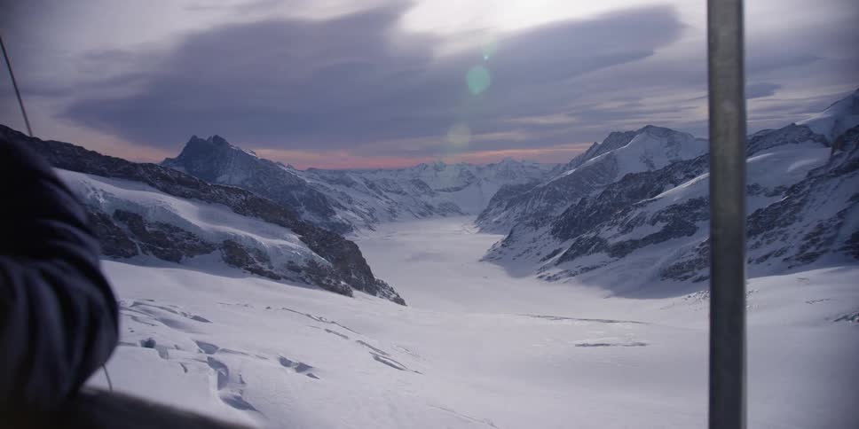 A person taking a photo of mountains covered in snow