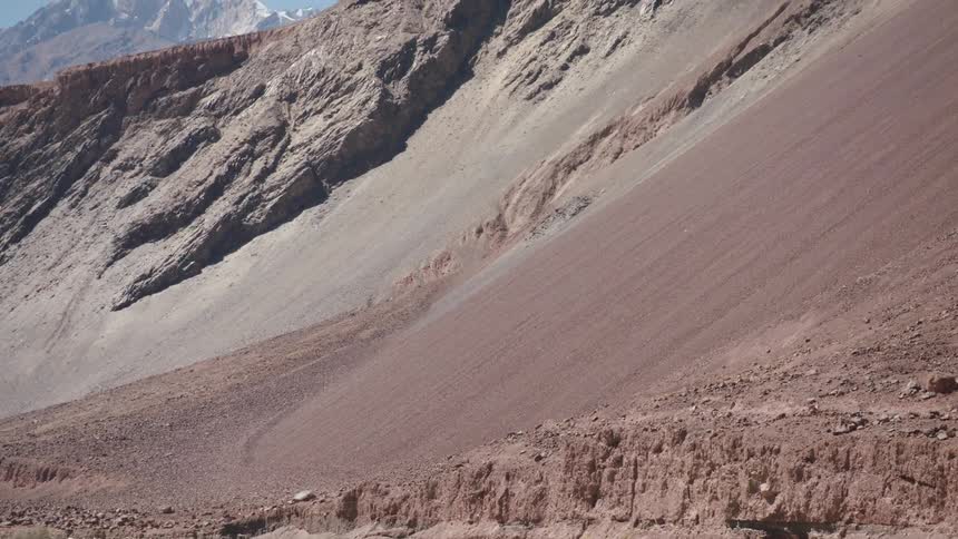 A small stream at the base of a mountain in a region with tall rock formations