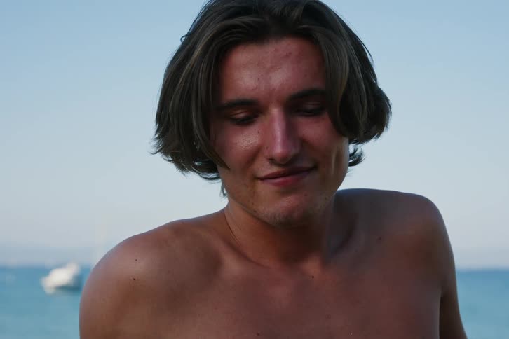 Portrait of a young man without a shirt in a natural environment by the sea