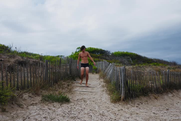 Two young men walk to a beach