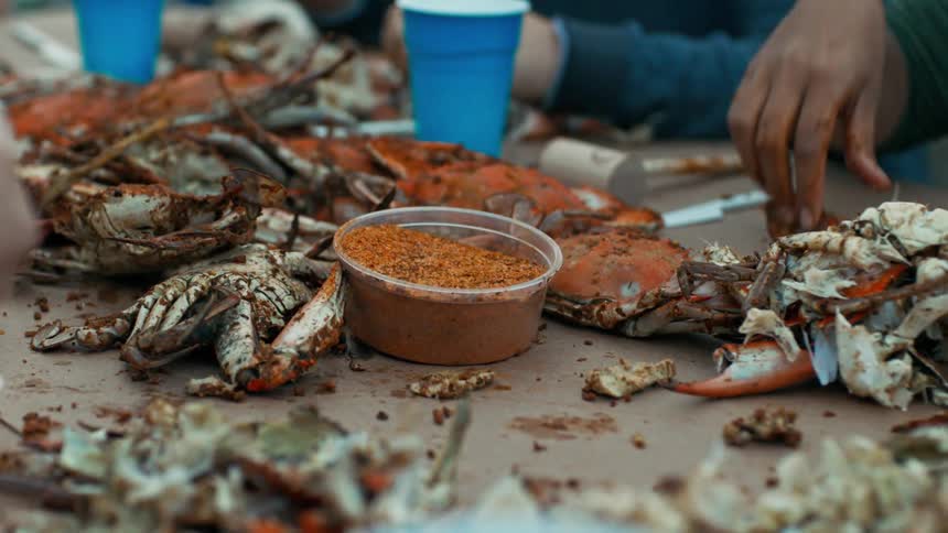 Hands of people on a table eating crab